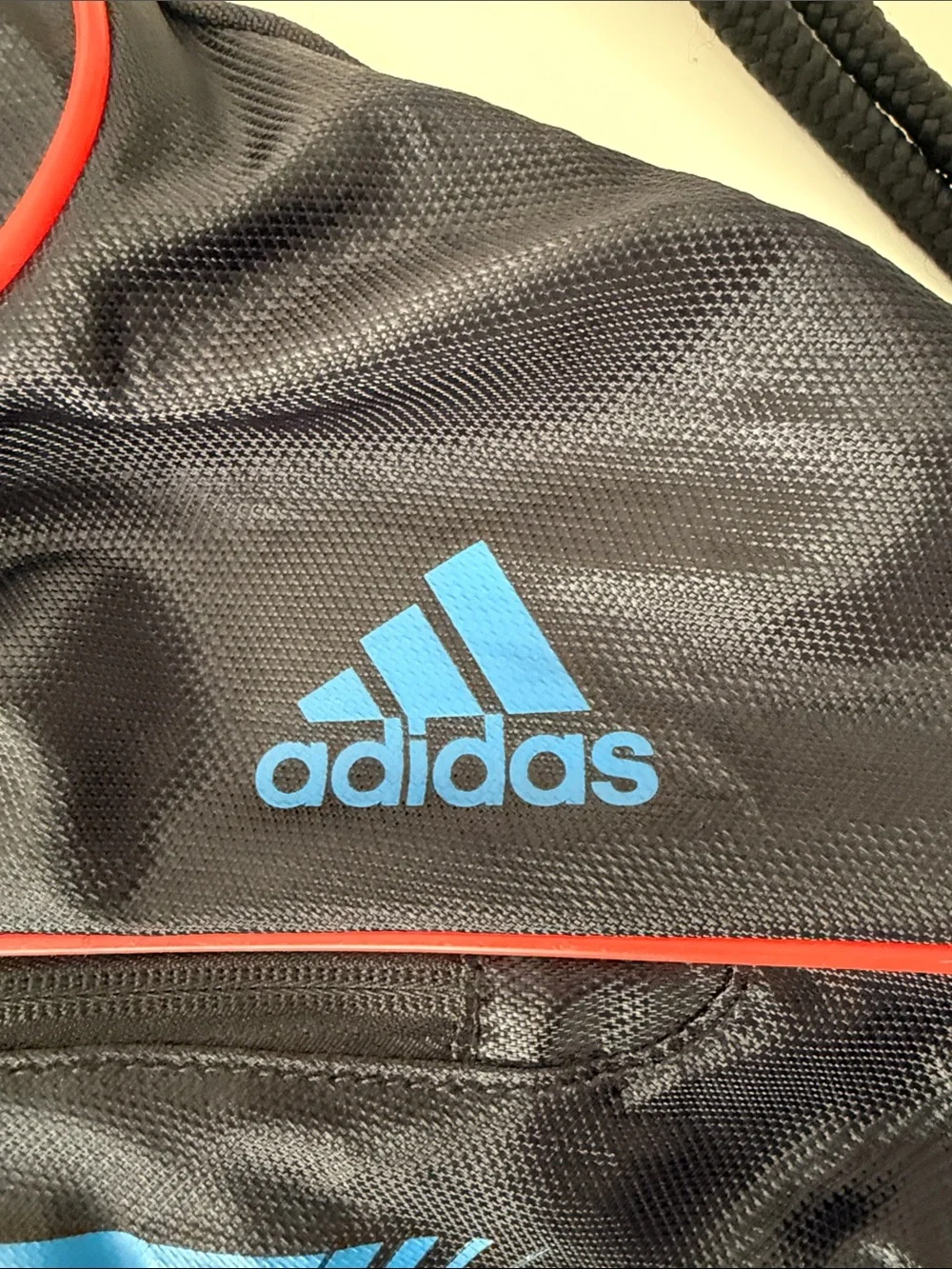 adidas Black Drawstring Backpack with Blue Stripes and Red Accents